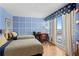Blue bedroom featuring two beds, a balcony with an ocean view, and a writing desk at 1180 Gulf Blvd # 1604, Clearwater Beach, FL 33767