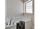 Corner bathtub with brushed nickel faucet and dark grey towel at 12220 Legacy Bright St, Riverview, FL 33578