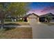 Inviting home featuring a two-car garage, stone accents, and manicured landscaping at dusk at 12220 Legacy Bright St, Riverview, FL 33578