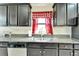 Kitchen features a stainless steel sink, gray granite counters, and black cabinets at 12220 Legacy Bright St, Riverview, FL 33578