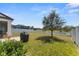 Lush backyard with a grill, white fence, and tree at 12377 Streambed Dr, Riverview, FL 33579
