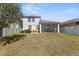 Expansive backyard view showcasing a large grass area and partial view of the home's exterior at 12377 Streambed Dr, Riverview, FL 33579