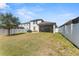 Large backyard featuring a white fence, screened in patio, and lush green grass at 12377 Streambed Dr, Riverview, FL 33579