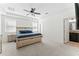 Bright and airy bedroom featuring a tray ceiling, ceiling fan, large bed, and ensuite bathroom at 12377 Streambed Dr, Riverview, FL 33579
