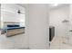 View from the hallway showing a bedroom with a bed and an adjacent laundry room with a washing machine and dryer at 12377 Streambed Dr, Riverview, FL 33579