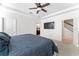 Cozy bedroom with a large bed, ceiling fan, and an ensuite bathroom with staircase views at 12377 Streambed Dr, Riverview, FL 33579