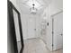 Bright foyer with tile flooring, decorative lighting fixture, and large mirror creating an open and inviting space at 12377 Streambed Dr, Riverview, FL 33579