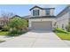 Inviting two-story home showcasing a lush landscaped front yard and a spacious two-car garage and driveway at 12377 Streambed Dr, Riverview, FL 33579