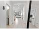 Bright hallway with tile floors leading to the open floor plan kitchen and living area, plus a half bath at 12377 Streambed Dr, Riverview, FL 33579