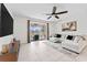 Bright living room featuring a ceiling fan, sliding glass doors, and neutral decor at 12377 Streambed Dr, Riverview, FL 33579