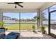 Inviting screened patio with brick floors, green grass, and views of the backyard and a lake at 12377 Streambed Dr, Riverview, FL 33579