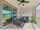 Inviting screened patio featuring wicker furniture, ceiling fan, and views of the lush green backyard at 12377 Streambed Dr, Riverview, FL 33579