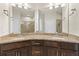 Bathroom featuring granite countertops, a large mirror, and double sinks at 12919 Whittington Ct, Largo, FL 33773