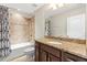 Bright bathroom featuring granite countertops, wood cabinets, tub with tile surround and shower at 12919 Whittington Ct, Largo, FL 33773