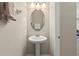 A half bathroom with a pedestal sink, a mirrored cabinet, and a neutral color scheme at 12919 Whittington Ct, Largo, FL 33773