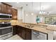 Open kitchen with granite countertops, stainless steel appliances, and dark cabinetry at 12919 Whittington Ct, Largo, FL 33773
