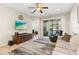 View of the open living room with tile flooring, a ceiling fan, and a sliding glass door at 12919 Whittington Ct, Largo, FL 33773