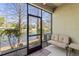 Enclosed patio overlooking tranquil water view with trees, green plants, welcome mat, and bench at 12919 Whittington Ct, Largo, FL 33773