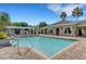 Community pool with lounge chairs, pergola, trees, and building with light-colored facade at 12919 Whittington Ct, Largo, FL 33773