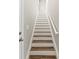 An interior shot of a staircase with white and brown steps, a white banister, and a light wall at 12919 Whittington Ct, Largo, FL 33773