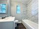 Bathroom featuring marble-look wall tile, modern vanity, and tub at 1409 Franklin St, Clearwater, FL 33756