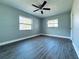 Bright bedroom with wood floors, ceiling fan, and natural light from two windows at 1409 Franklin St, Clearwater, FL 33756