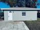 Exterior view of the home with a white door, pavers, and a window at 1409 Franklin St, Clearwater, FL 33756