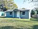 Inviting single-story home with fresh gray paint, white trim, and a well-manicured front lawn at 1409 Franklin St, Clearwater, FL 33756