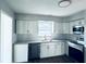 Well-lit kitchen with white cabinets, subway tile backsplash, granite countertops, and stainless steel appliances at 1409 Franklin St, Clearwater, FL 33756