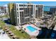Aerial view of a condo building and pool overlooking the blue waters of the ocean at 1480 Gulf Blvd # 401, Clearwater Beach, FL 33767