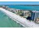 Stunning aerial view of beachfront condos along a sandy beach with blue ocean waters on a sunny day at 1480 Gulf Blvd # 401, Clearwater Beach, FL 33767