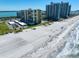 Aerial view of a beachfront condo building with manicured landscaping, pool, and beach access at 1480 Gulf Blvd # 401, Clearwater Beach, FL 33767