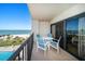 Balcony with chairs, table, and ocean view at 1480 Gulf Blvd # 401, Clearwater Beach, FL 33767