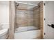 Modern bathroom featuring a bathtub with a sliding glass door and tiled walls at 1480 Gulf Blvd # 401, Clearwater Beach, FL 33767