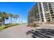 Exterior view of a building with a circular driveway, landscaping and beach view at 1480 Gulf Blvd # 401, Clearwater Beach, FL 33767