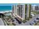A beautiful high-rise condo building boasts a parking lot, palm trees, and a pool near the ocean at 1480 Gulf Blvd # 401, Clearwater Beach, FL 33767