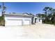 New construction home featuring a 3-car garage and covered front porch in a sunny, wooded setting at 15513 Aldama Cir, Port Charlotte, FL 33981