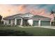 Beautiful single-story home featuring a three-car garage, a well-manicured lawn and professional landscaping at 15513 Aldama Cir, Port Charlotte, FL 33981
