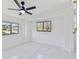 Well-lit bedroom featuring tiled floors, a ceiling fan, and bright windows with neighborhood views at 1600 Delaware Ne Ave, St Petersburg, FL 33703