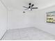 Bright bedroom with white walls, tiled floors, ceiling fan, and natural light from the window at 1600 Delaware Ne Ave, St Petersburg, FL 33703