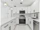 Modern kitchen featuring white cabinetry, stainless steel appliances, and marble countertops at 1600 Delaware Ne Ave, St Petersburg, FL 33703