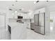 Modern kitchen with white cabinets, stainless steel appliances, island, and a french-door refrigerator at 1600 Delaware Ne Ave, St Petersburg, FL 33703