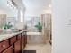 Bathroom featuring double vanity, soaking tub, and glass enclosed shower at 17533 Timberline Pkwy, Punta Gorda, FL 33982