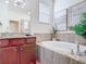 A modern bathroom features a soaking tub, granite countertops, and stylish decor at 17533 Timberline Pkwy, Punta Gorda, FL 33982