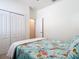Bright bedroom with patterned bedding, closet, and doorway to another room at 17533 Timberline Pkwy, Punta Gorda, FL 33982