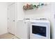Clean laundry room featuring a modern washer and dryer, plus overhead shelving for storage and organization at 17533 Timberline Pkwy, Punta Gorda, FL 33982