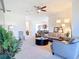 Open-concept living room with stylish furnishings, a ceiling fan, and a seamless flow into the dining and kitchen areas at 17533 Timberline Pkwy, Punta Gorda, FL 33982