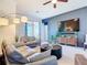 Inviting living room with comfortable seating, large TV, ceiling fan, and sliding glass doors leading to outdoor area at 17533 Timberline Pkwy, Punta Gorda, FL 33982