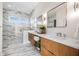 Modern bathroom features double sinks, marble countertops, wooden cabinets, and a glass enclosed walk-in shower at 187 145Th E Ave # 4, Madeira Beach, FL 33708