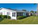 The exterior features a screened-in lanai with an attached trailer, lush lawn, and exterior access at 1902 Andover St # 198, Sun City Center, FL 33573